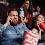 man on mobile phone in cinema