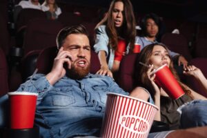 man on mobile phone in cinema